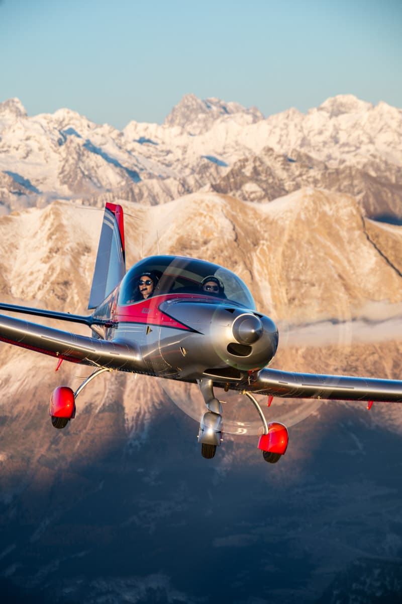 Bristell B23 climbing past alpine peaks